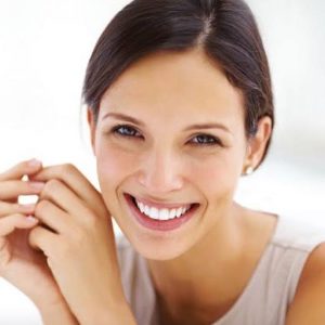 Woman smiling about the cost of dentistry image